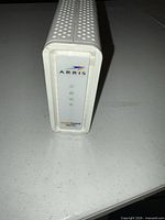 Front view of white Arris SB6183 modem showing logo and LED panel