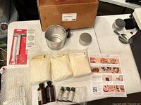 Full kit layout with wax bags, pitcher, tins, bottles, thermometer, wicks, instructions and box