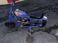 Left side profile of blue mini bike showing frame, engine, chain drive, seat and tires