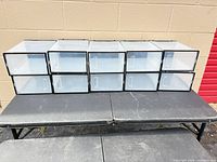 Front view of 10 stacked translucent plastic shoe boxes showing clear doors and black frames