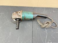 Full view of Makita angle grinder with cord and side handle