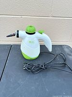 Full view of handheld steam cleaner with power cord