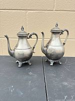 Front view of both silver-on-copper teapots