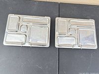 Front view of two PlanetBox stainless steel compartment lunchboxes closed