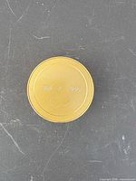 Closed round gold-tone clock showing engraved cover