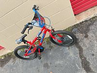 Full view of red Schwinn kids bike against wall
