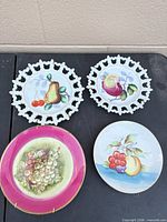 All four plates displayed, showing motifs and two plate hangers