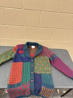 Front view of cardigan laid flat showing full design and buttons