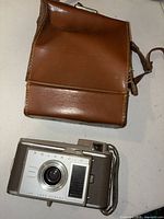 Front view of Polaroid J33 camera and leather case