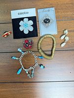 All seven jewelry pieces arranged on wooden surface