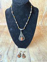 Full view of necklace on bust with earrings below