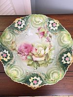 Top view of ornate porcelain bowl showing floral pattern and green rim