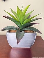 Front view of artificial succulent in gray metal planter