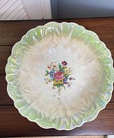 Top view of bowl showing scalloped green rim and floral center