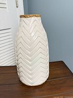 Full view of white chevron ceramic vase with beige rim