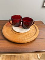 Teak tray with marble insert and ruby red glass creamer and sugar displayed on top