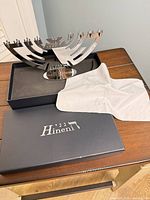 Menorah resting in fitted box with cloth and separate box lid visible