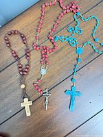 All three rosaries laid out to show full length and crosses