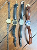 All four wristwatches laid out side by side