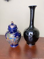 Front view of cobalt blue ginger jar and black bud vase