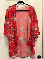 Front view of red floral kimono cardigan on hanger
