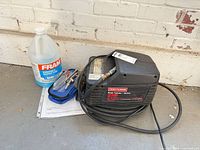 Wide view showing Craftsman compressor, manual, attachments, and Fram windshield fluid