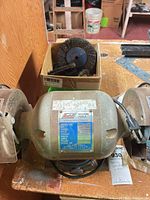 Front view of Ludell bench grinder with accessories box behind