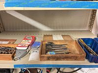 shelf view showing countersink bits box, chalk line plumb line, spade bits tray and twist bits