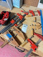 Assorted bar clamps, hand screw clamp and utility hooks on workbench