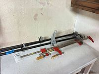 Overall view of three pipe clamps and three bar clamps on tabletop