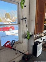 Edger and trimmer standing against wall