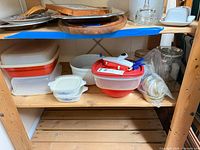 Wide view of shelving unit showing plastic containers, CorningWare dishes, mixing bowl, canisters and accessories