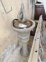 Full view of resin pedestal fountain showing finial, bowl, and wiring