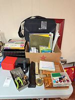 Overall lot view showing briefcase, trays, file folders, desk tools and craft box