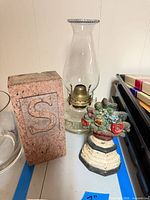 Front view of granite block, oil lamp, and painted door stop