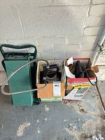 Two boxed sprayers and folded garden bench