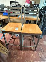 Front view of both stools showing metal frames and wooden seats