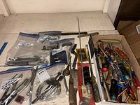 Overview of tray with screwdrivers, calipers, files, bagged hardware