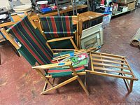 Two striped canvas wood deck chairs with footrests and canopy parts
