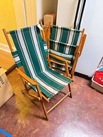 Two wood folding chairs with striped green canvas