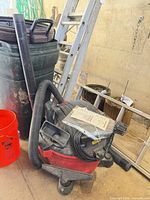 Craftsman wet/dry vacuum with hose and wands beside bucket and ladder
