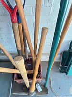Handled tools in crate: axe, pick, sledge hammer, visible handles