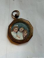 Front view of octagonal pendant showing painted portrait, engraved frame and bail