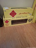 Stacked Aristo Craft yellow boxes, showing 100-ton hopper car label and second gondola car box