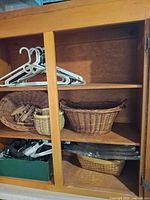cabinet shelf with baskets, hangers and clothespins