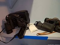 Both pairs of binoculars and case on shelf