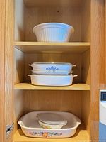 Cabinet view showing five bakeware pieces on three shelves