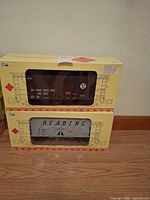 Two boxed Aristo-Craft hopper cars stacked