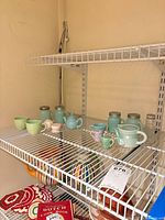 Shelved view showing espresso cups, Mason jar shakers, miniatures and striped pitchers