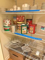 Wide view of shelving showing all tins and plastic box